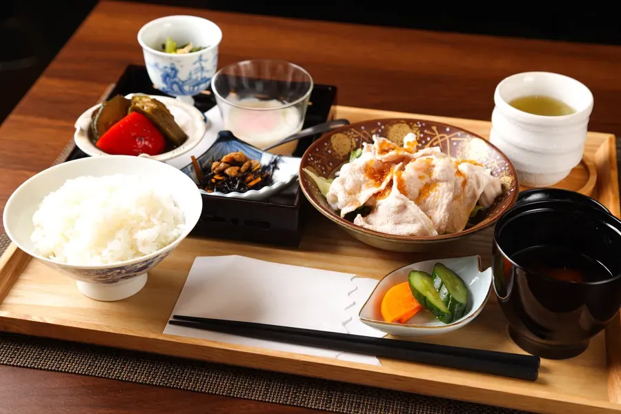ご飯と小鉢、汁物を木のお盆にのせた和食の定食