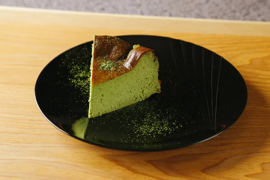 黒い皿にのせた抹茶のバスクチーズケーキ