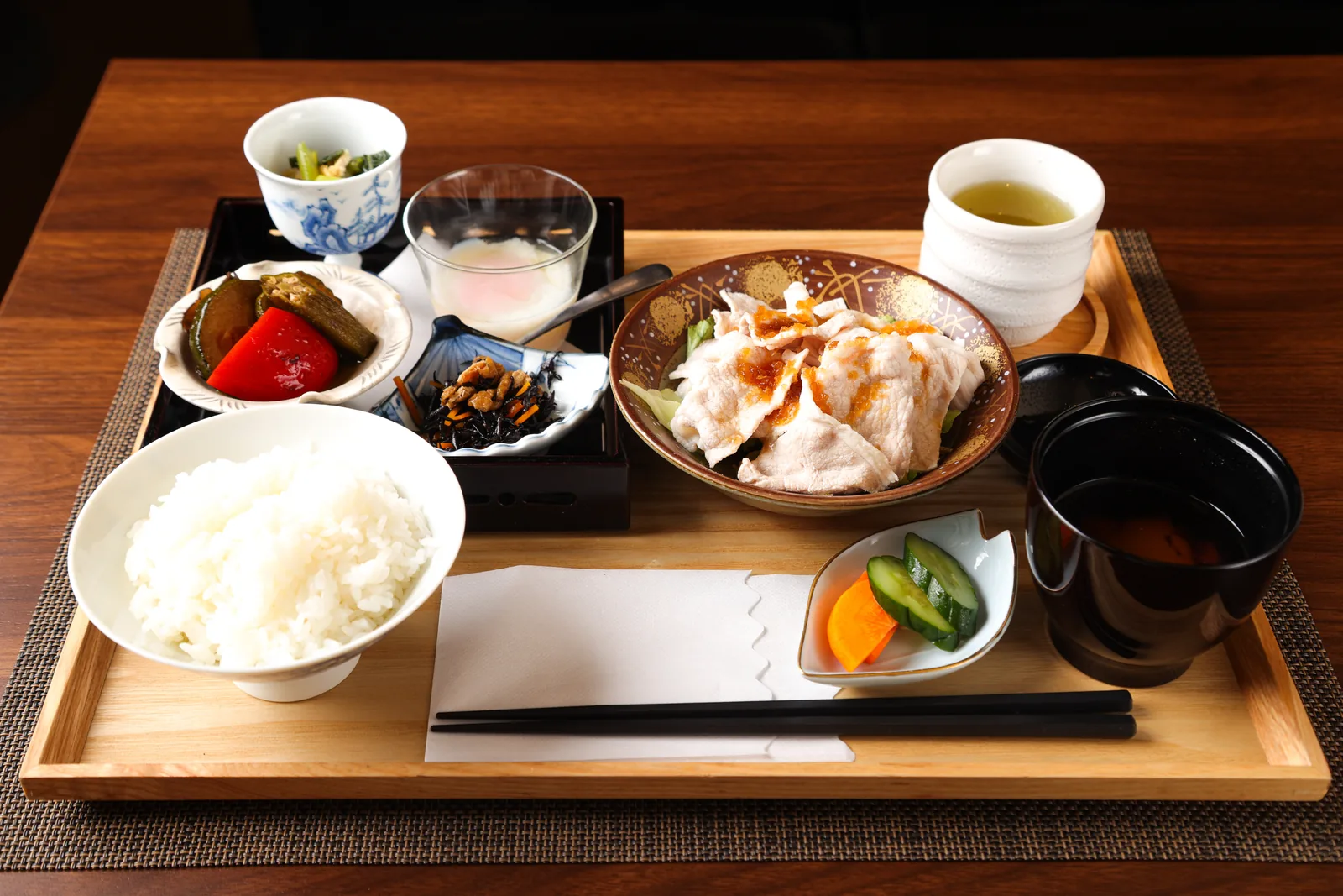 ご飯と小鉢、お吸い物を木のお盆にのせた和食の定食